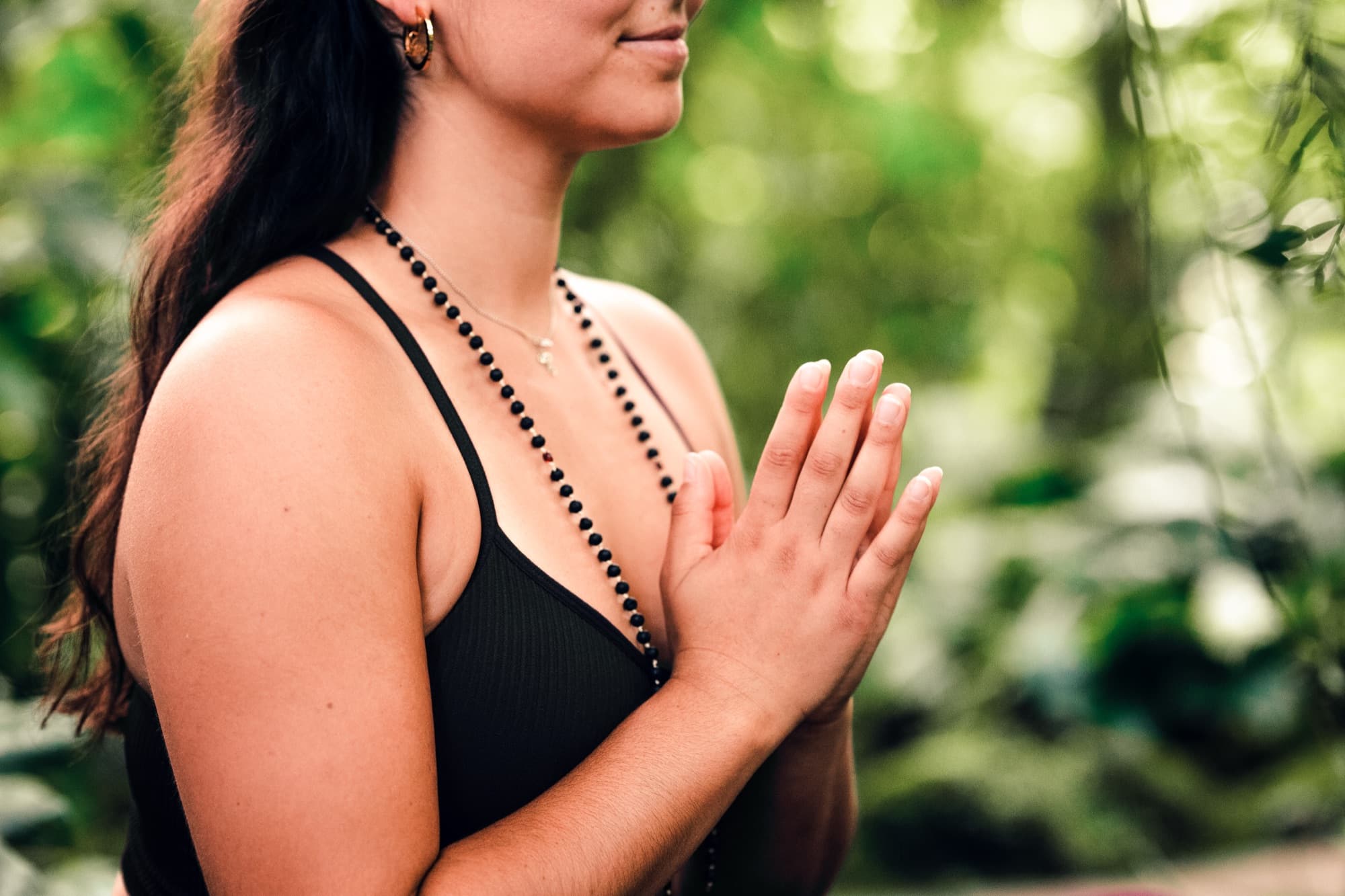 Nahaufnahme von Sophie mit Mala-Kette und gefalteten Händen beim Yoga & Brunch Workshop
